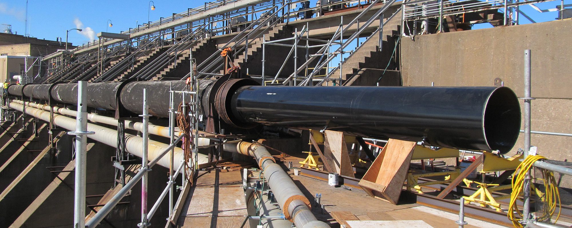 A large black pipe and scaffold at a paper mill facility