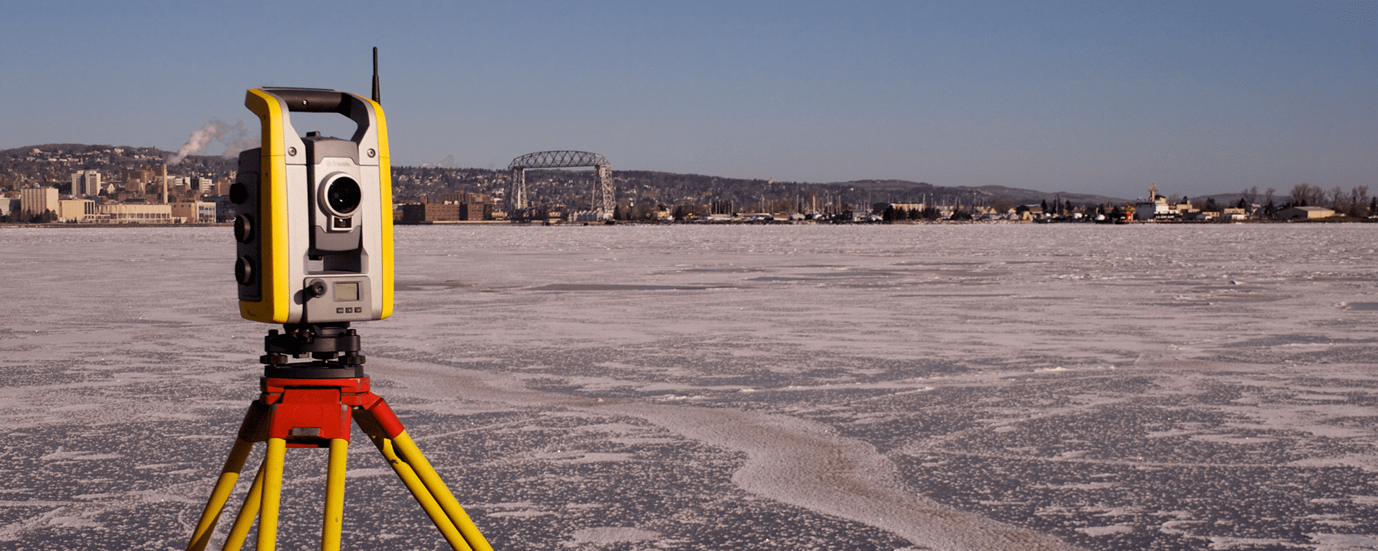 survey equipment with frozen lake and skyline in the background