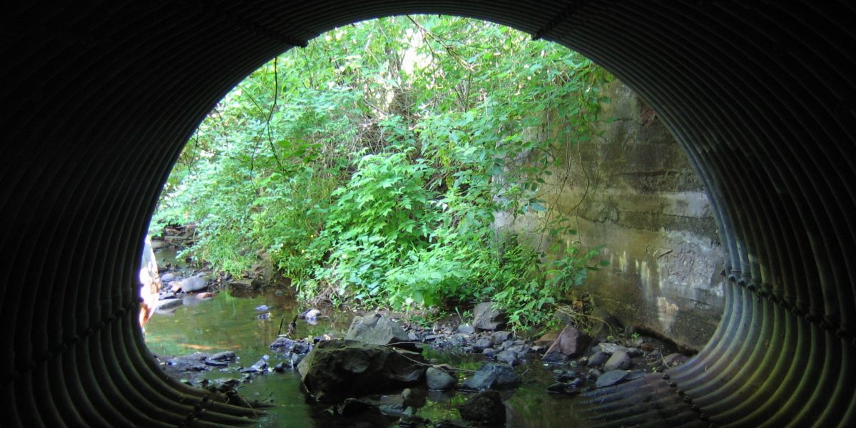 Inside of round culvert with water flowing through